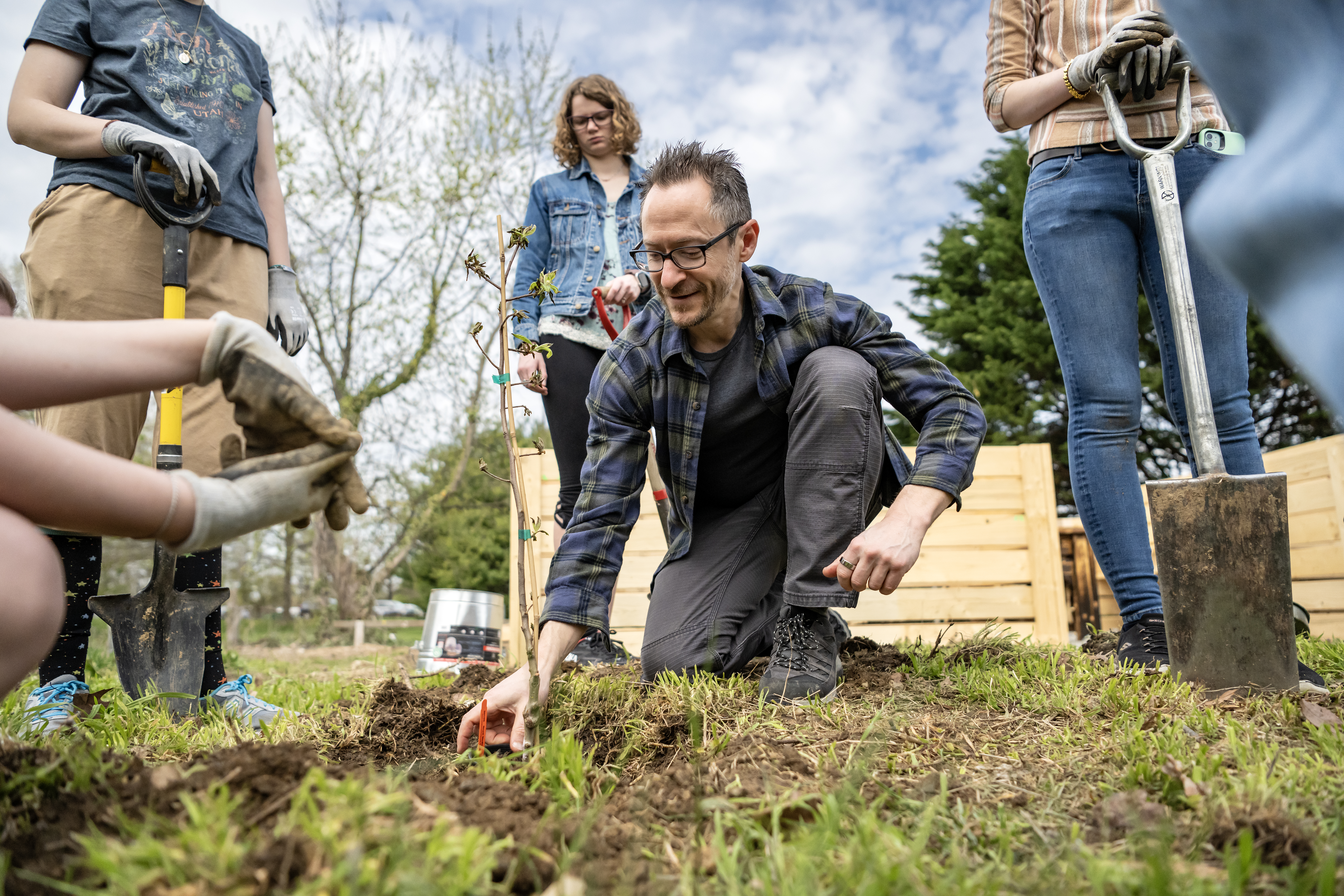 Campus Garden Director Shane Brill helps plant trees in the new Poetry Garden at Washington College.