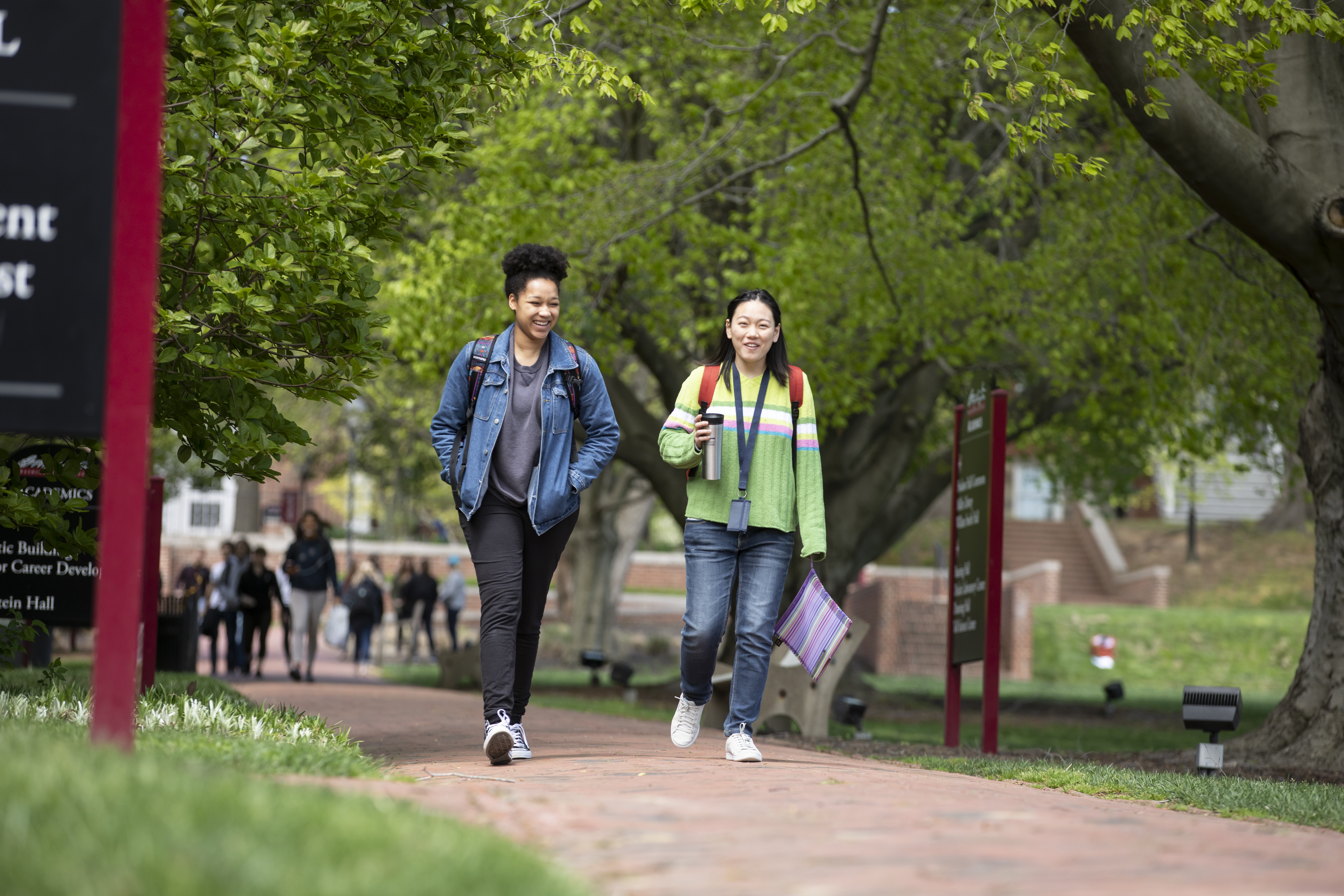 Two Washington College students walk and smile 