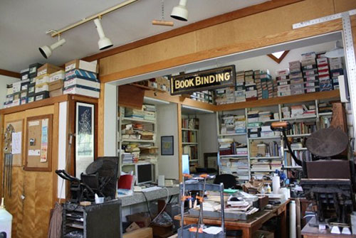 Book Binding nook located in the Literary House filled with papers and books and antique letter presses