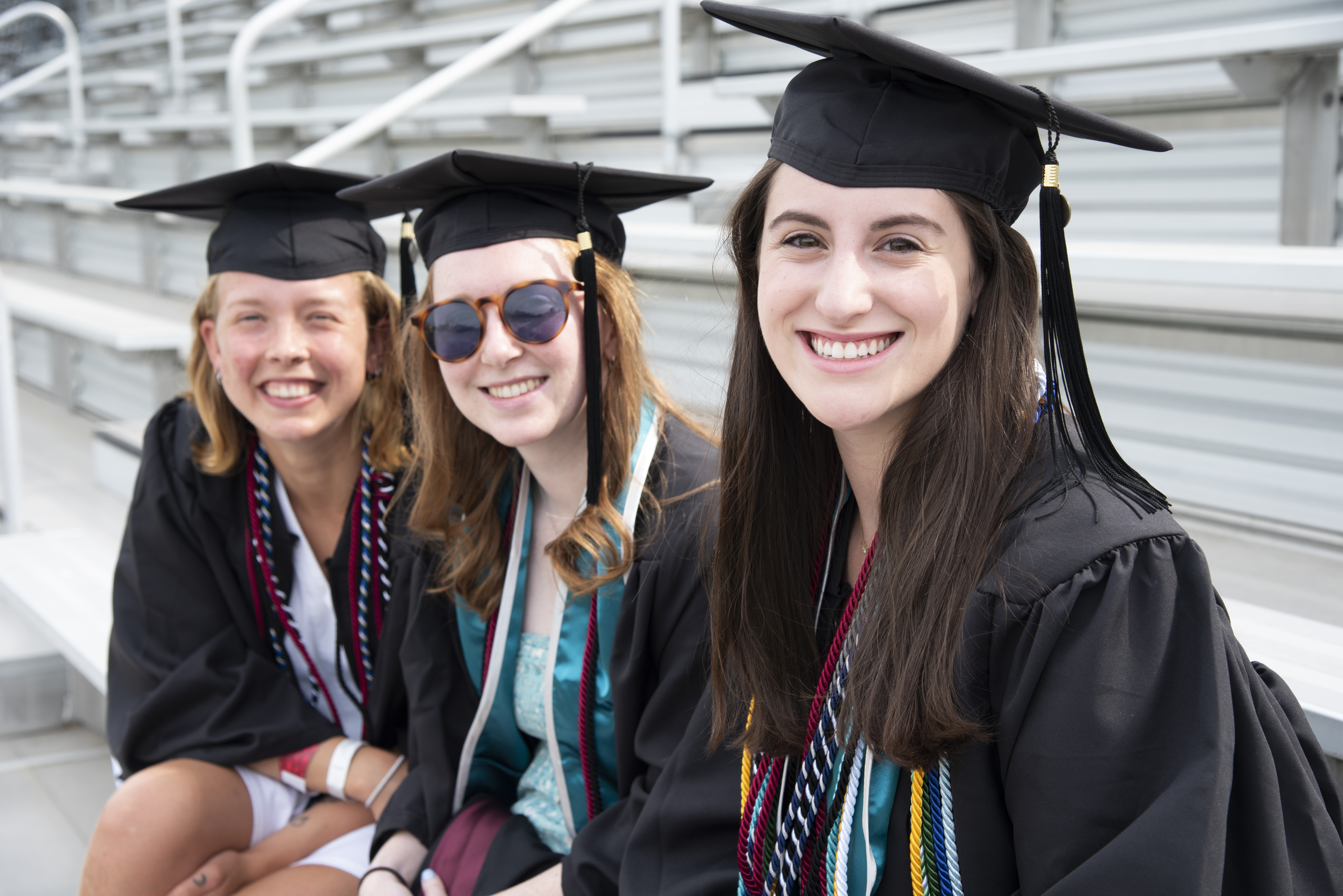 Three Washington College graduates smiling