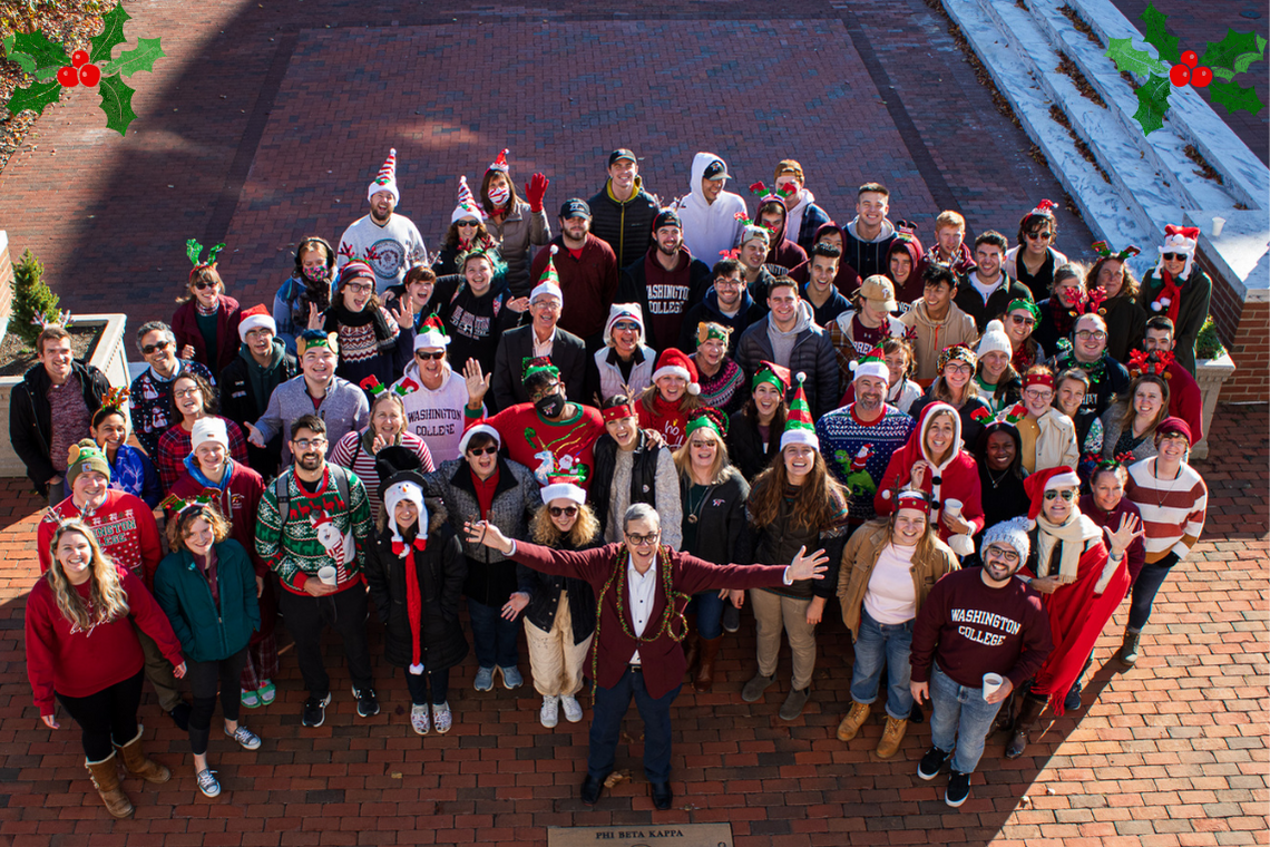 staff, faculty, and students smiling in holiday gear at the heart of campus