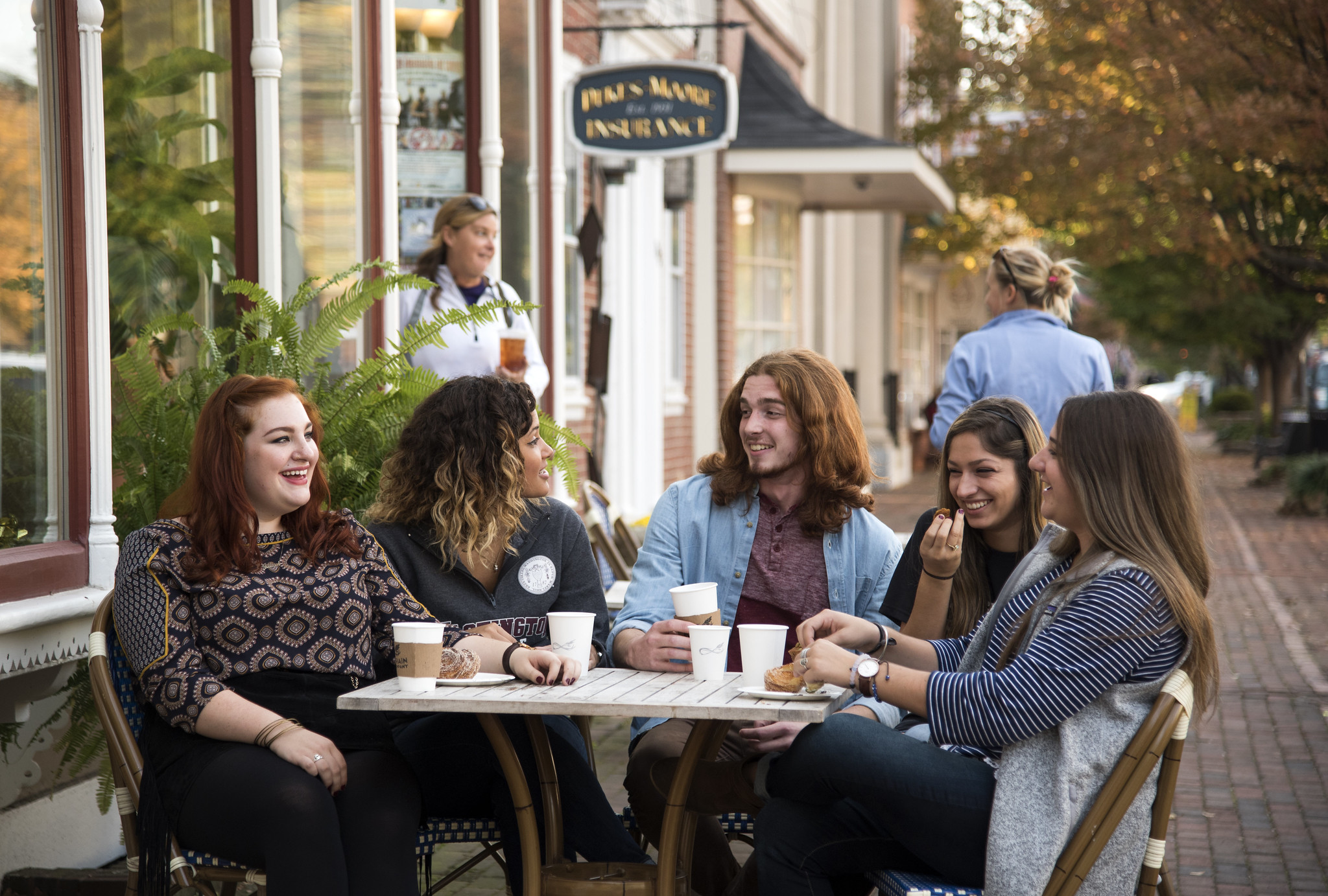 a group of people sitting around an outdoor dining table