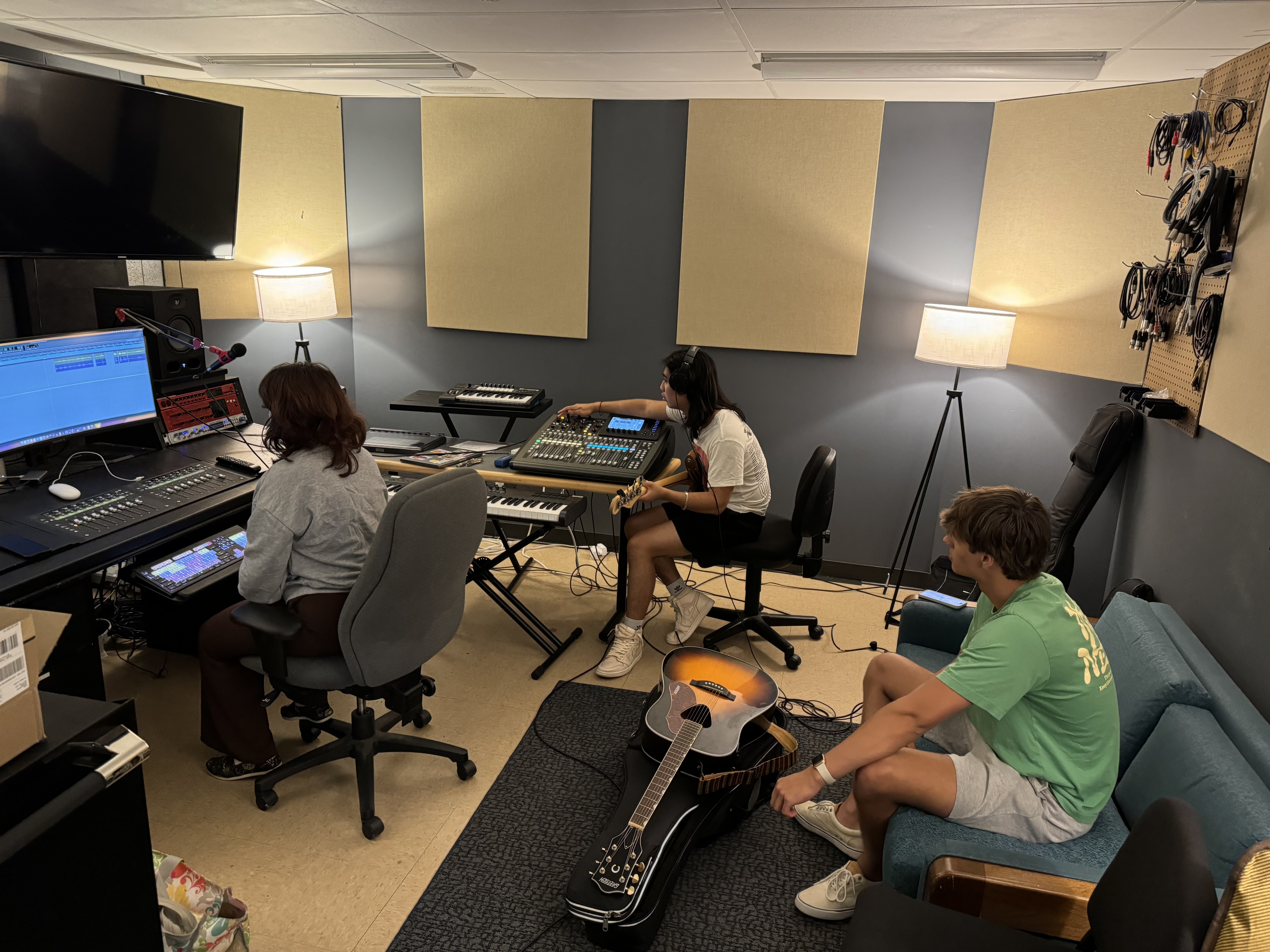 student adjusting a soundboard while recording