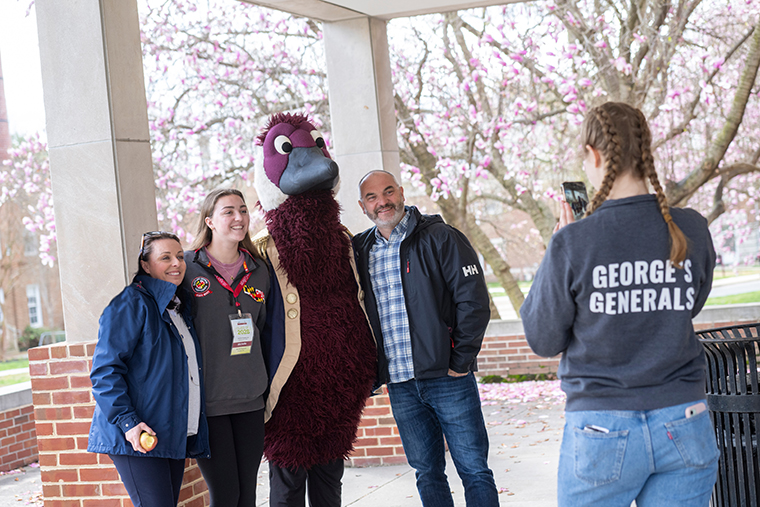 a family gets their picture taken with Gus the Goose mascot