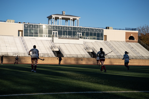 women playing field hockey in stadium