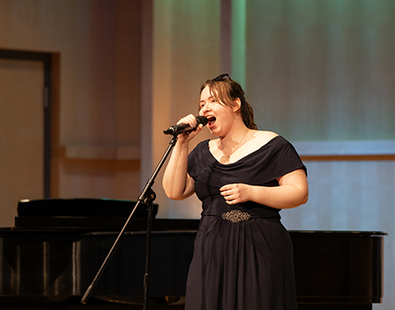 a woman sings into a microphone