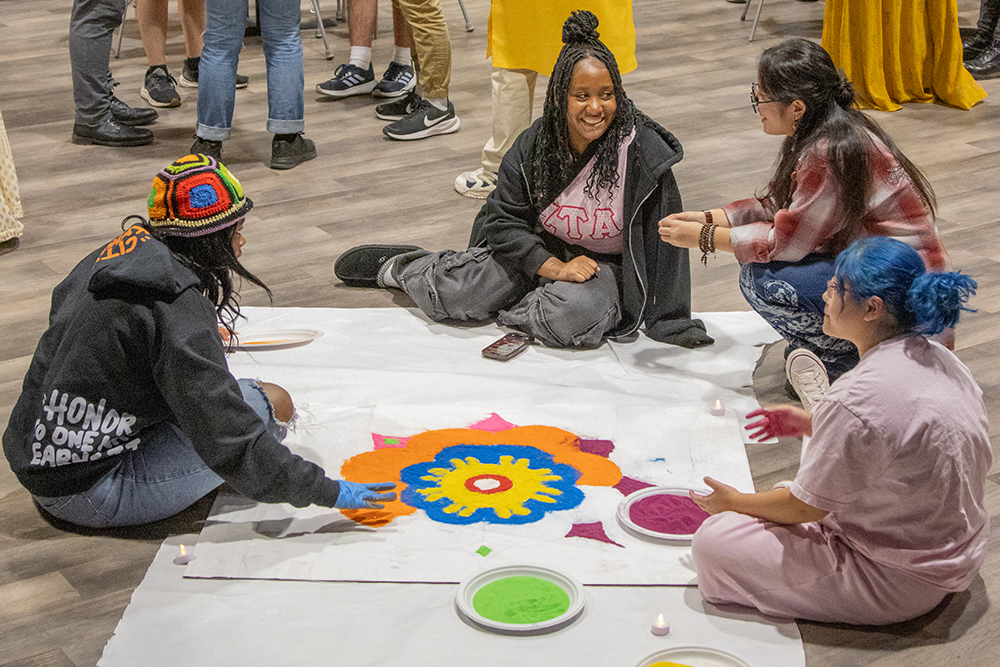 Students on the floor making sand art mandala