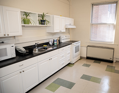 row of kitchen cabinets, sink, and appliances