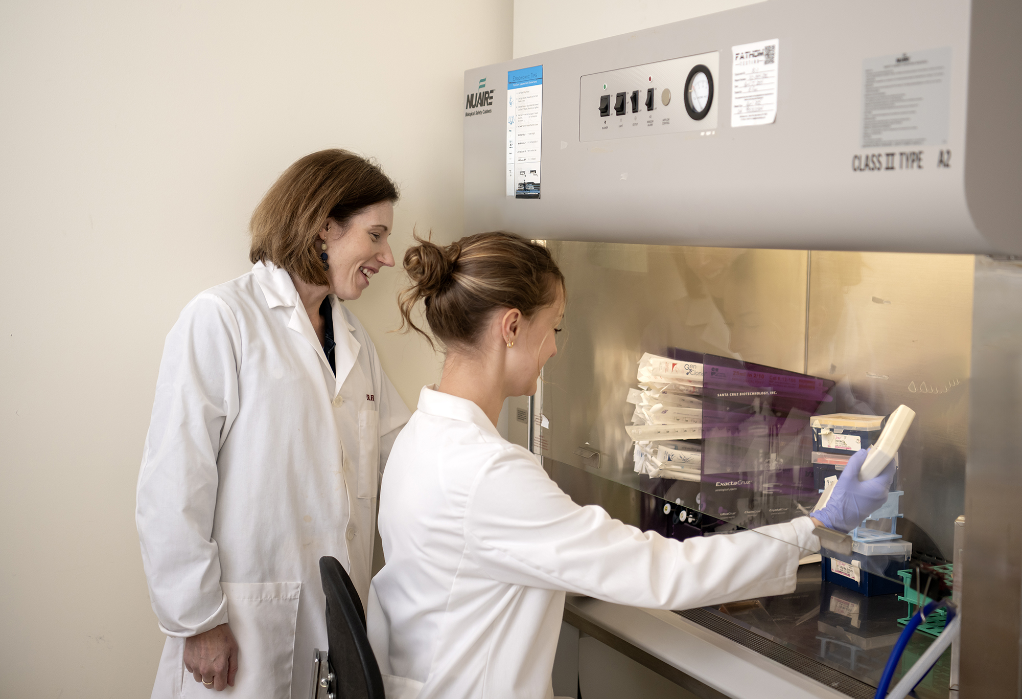 student working in the lab with a professor