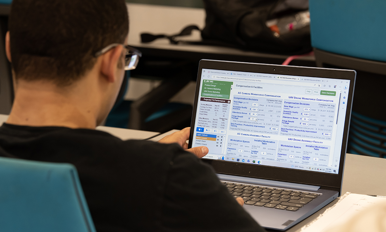 a student reviews business data on a laptop