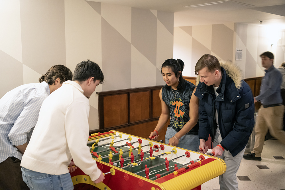 students play foosball in the golden goose pub