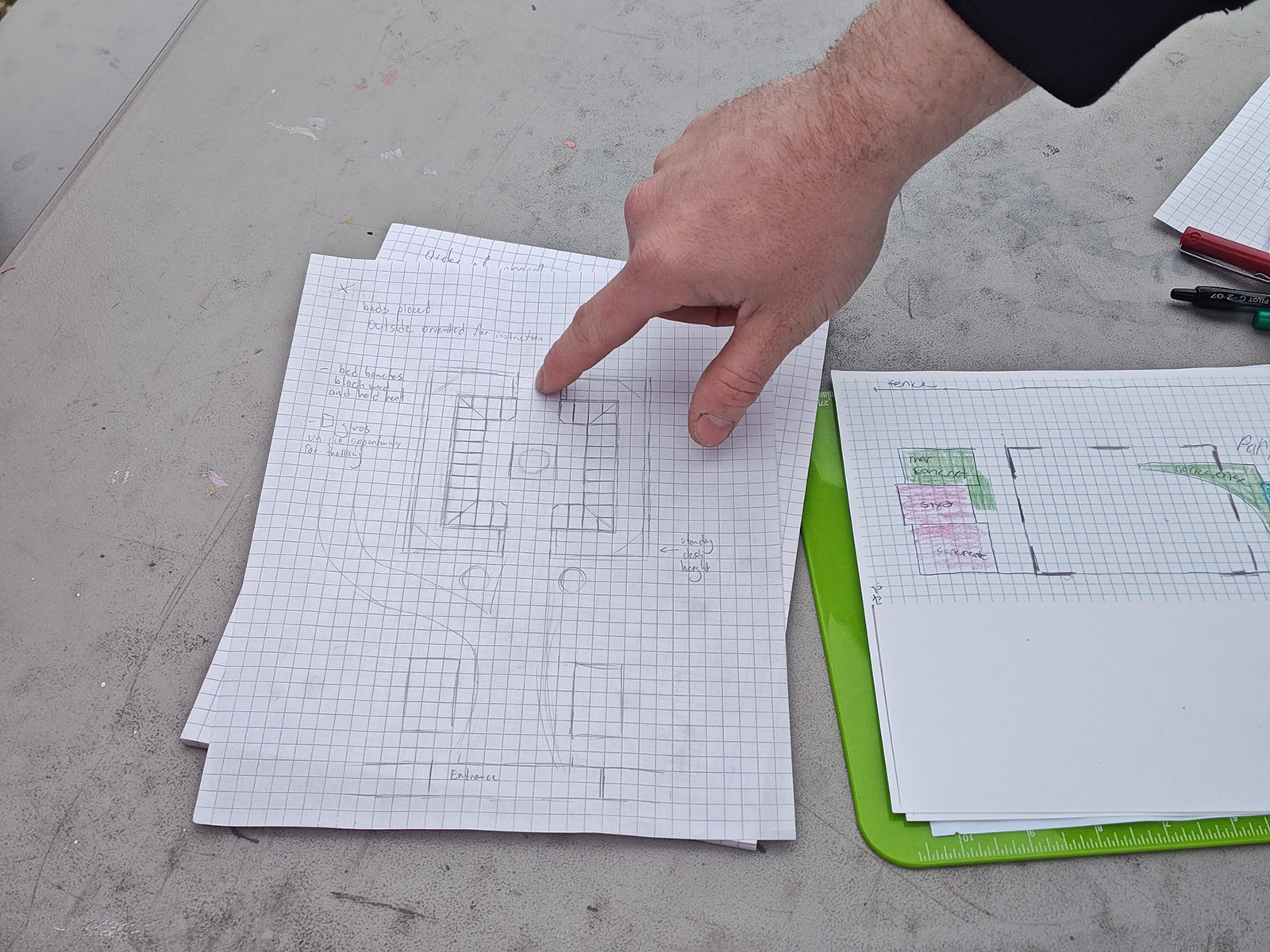 Student pointing at poetry garden blueprint