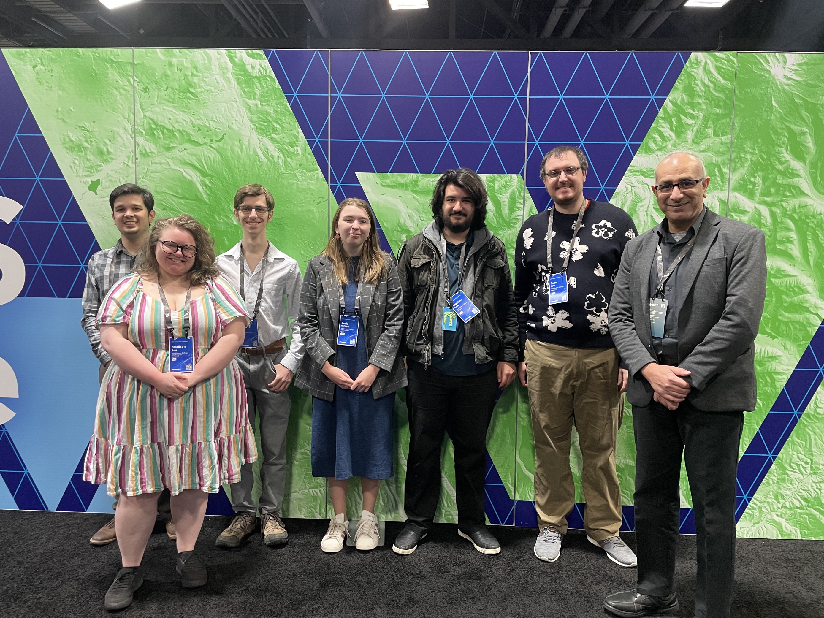 GIS staff in front of a map graphic