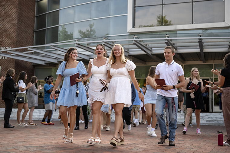 Members of the Class of 2028 leave Fall Convocation as older students clap and cheer for them.