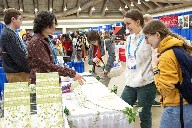 Rose O'Neill Literary House Center Coordinator Justin Nash '21 (left) and Leo De Luca '28 man the Cherry Tree booth at AWP