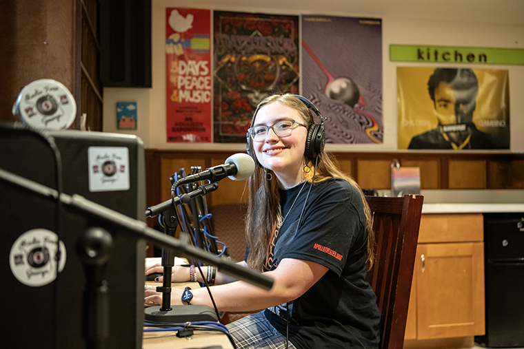 Faith Jarrell sits at the recording desk in Radio Free George