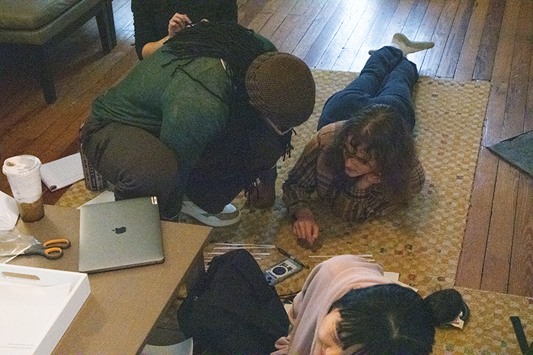 jericho brown crouches with a student to look at the duplex poem she's working on