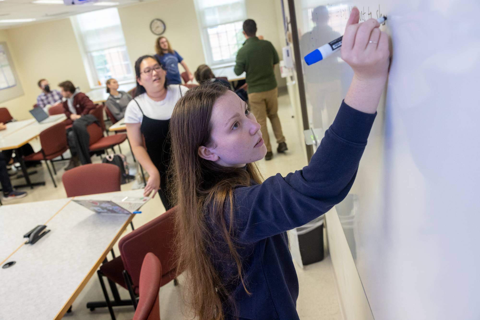 student writing on white board