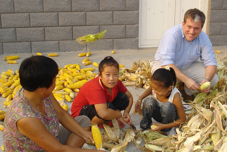 Matt Murray '95 helps a family shuck corn