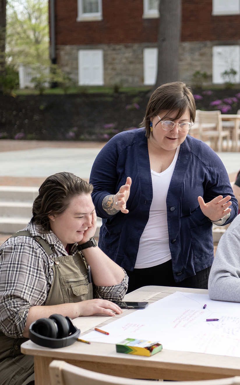 Professor Sara Clarke-De Reza talks with a student on the library terrace